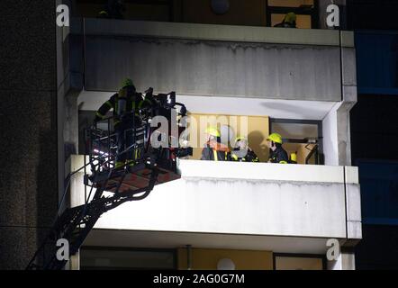 17 Dezember 2019, Hessen, Frankfurt/Main: Feuerwehrmänner der Feuerwehr die Brandbekämpfung Arbeit von einem Wohnungsbrand in einem Hochhaus auf dem Balkon. Auf den ersten, wurde nichts über mögliche Verletzungen bekannt. Foto: Boris Roessler/dpa Stockfoto