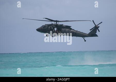 Us-Armee besondere Bedienung Soldaten führen eine helocast Einfügen von einem UH-60 Black Hawk Hubschrauber während Special Patrol Insertion und Extraktion Ausbildung bei Faltenbalg Air Force Station Dezember 5, 2019 in Kaneohe, Hawaii. Die wässrige Kurs ist so konzipiert, dass Soldaten mit Helocasting und wässrige Arbeiten vertraut zu machen. Stockfoto