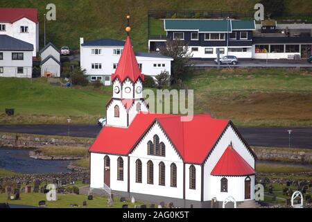 Sandavagur, Färöer, Dänemark - 15 September 2019 - Sandavagur Kirche mit rotem Dach auch Sandavags Kirkja und den Fluss Stora Stockfoto