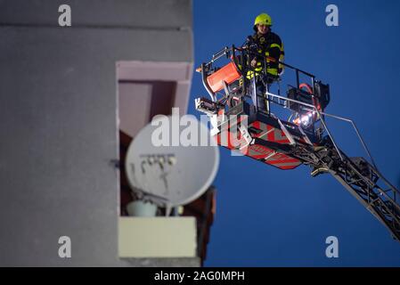 17 Dezember 2019, Hessen, Frankfurt/Main: Mit Hilfe einer Hebebühne, Feuerwehrmänner der Feuerwehr Blick in eine Wohnung nach einem Wohnungsbrand in einem Hochhaus. Auf den ersten, wurde nichts über mögliche Verletzungen bekannt. Foto: Boris Roessler/dpa Stockfoto