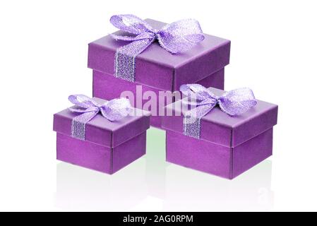 Drei hot pink, lila, Geschenkboxen isolieren auf einem weißen Hintergrund, Nahaufnahme, Reflexion. Stockfoto