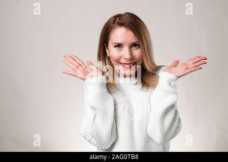 Bild von überrascht Frau mit Brille und in weißen Pullover über Hintergrund weiß gekleidet. An der Kamera Stockfoto