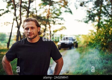 Porträt der Menschen, die in den Wald und sieht in der Natur steht. Automobil hinter geparkt Stockfoto