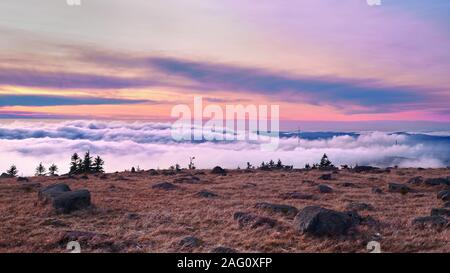 Auf dem Berg oben bei Sonnenuntergang über einem Meer von Wolken. Ein Himmel in schönen Farben, Brocken, Harz, Sachsen-Anhalt, Deutschland. Stockfoto