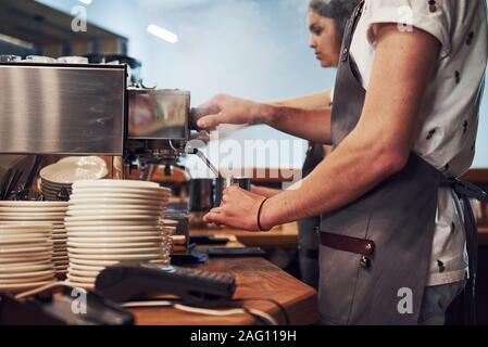 In Uniform. Zwei junge cafe Mitarbeiter im Innenbereich. Konzeption von Business und Service Stockfoto