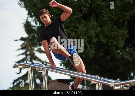 Springen über Hindernisse. Junge sport Mann tun Parkour in der Stadt am sonnigen Tag Stockfoto