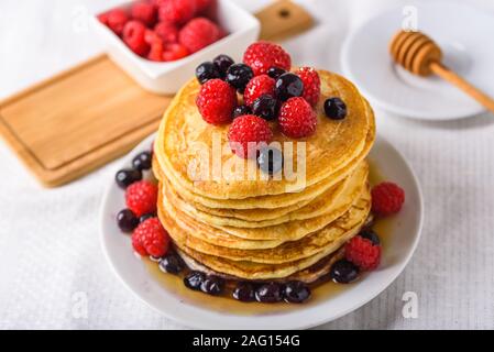 Süße hausgemachte Pfannkuchen mit Himbeeren auf weißer Teller mit Gabel. Stockfoto