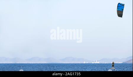 Murcia, Spanien, 23. August 2019: Sportler üben hydrofiol Kite surfen an einem windigen Tag an den spanischen Küsten. Tragflächenboot Kite Surfer an der Spanischen se Stockfoto