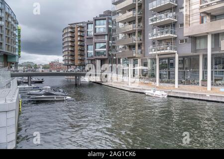 OSLO, Norwegen - 21. Juli 2019: zeitgenössische Architektur und Boote im Quay in Canal an Tjuvholmen Stadterneuerung neighborough, Schuß bei bewölktem Helle Stockfoto