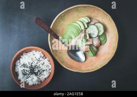 Vegane grüne marinierter Tofu poke Schüssel mit Avocado, Gurke, vegane Soße und Reis in Keramik Platte, auf pflanzlicher Basis Gourmet-menü, Ansicht von oben Stockfoto