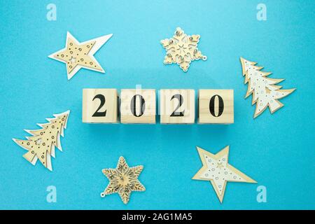 Holzwürfel mit der Inschrift 2020 auf einem blauen Hintergrund mit Holzspielzeug. Stockfoto