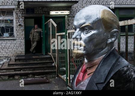 Büste von Wladimir Iljitsch Lenin am Eingang in den Bereich der Duga-1 (auch als ANDR-1 oder Russischen Specht) in der Nähe von Tschernobyl innerhalb der Sperrzone von Tschernobyl. Im Hintergrund ist eine Ukrainische Arbeiter aus der Checkpoint gesehen. Sperrzone von Tschernobyl, Invankiv Rajon, Oblast Kiew, Ukraine, Osteuropa Stockfoto