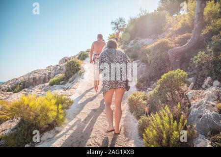 Zakynthos, Griechenland, August 2019 - weg vom Strand in Porto Limnionas Strand auf Zakynthos Insel. Junge Frau und Mann auf dem Weg zum Strand. Stockfoto