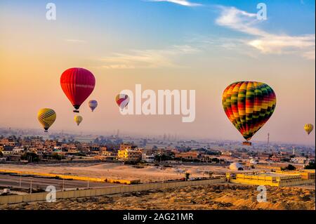 Heißluftballone fliegen über die West Bank von Luxor bei Sonnenaufgang Stockfoto