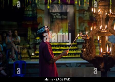 Ubud, Bali, Indonesien - 3. September 2017: man Kerzen anzünden am Anfang einer kecak Fire Dance Zeremonie. Am Abend ohne Blitz aufgenommen, Stockfoto