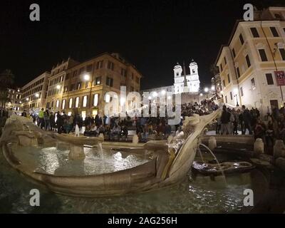 Abendschuss - Touristen auf spanischen Stufen und eine bootförmige Fontana della Barcacciaon Piazza di Spagna in Rom, Italien, April 2019. Stockfoto