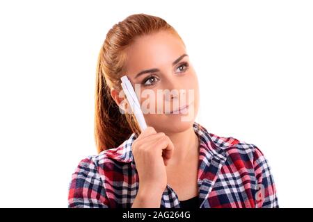 Denken Konzept. Nahaufnahme, Porträt einer schönen jungen Frau in Plaid Shirt mit einem Stift zu Ihrem Kopf, zu denken und zu versuchen, ein Problem zu lösen. Stockfoto