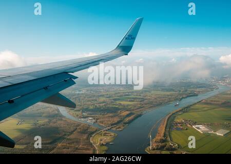 Amsterdam, Niederlande, November 2019: Airplane Wing und Company Logo von KLM Airlines und Antenne Landschaft Blick aus dem Flugzeug Stockfoto