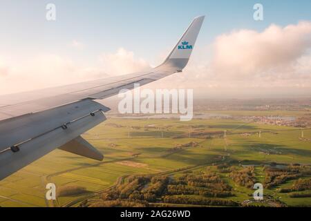 Amsterdam, Niederlande, November 2019: Airplane Wing und Company Logo von KLM Airlines und Antenne Landschaft Blick aus dem Flugzeug Stockfoto