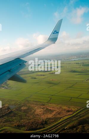 Amsterdam, Niederlande, November 2019: Airplane Wing und Company Logo von KLM Airlines und Antenne Landschaft Blick aus dem Flugzeug Stockfoto