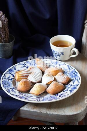 Lavendel madeleines auf einem porzellanteller auf blauem Hintergrund. Im rustikalen Stil. Stockfoto