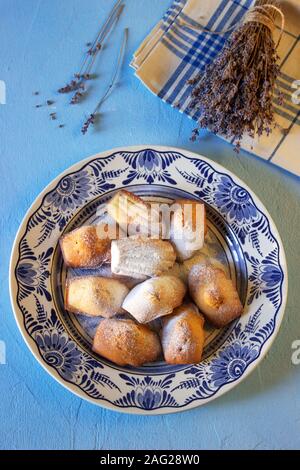 Lavendel madeleines auf einem porzellanteller auf blauem Hintergrund. Im rustikalen Stil. Stockfoto