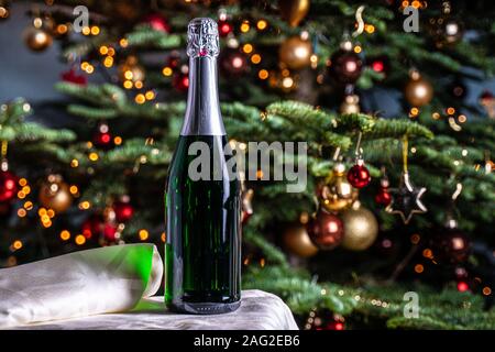 Eine Flasche Champagner in den Hintergrund der Weihnachtsbaum Stockfoto