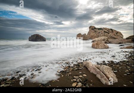 Meereslandschaft mit windigen Wellen an der felsigen Küste der Felsen der Aphrodite in Paphos, Zypern. Fotos mit langer Belichtungszeit. Stockfoto