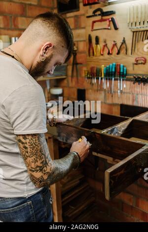 Handwerker Künstler Anwendung lack Lack auf Holz Möbel Handwerk workshop Stockfoto