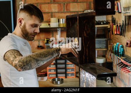 Handwerker, Künstler mit einem Besen und Anwendung lack Lack auf Holz Möbel Handwerk workshop Stockfoto