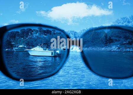 Sonnenbrille gegen den blauen Himmel und Meer, Sommerurlaub Reise Konzept. Blick durch eine Brille. Classic blau Farbe 2020 Konzept. Stockfoto