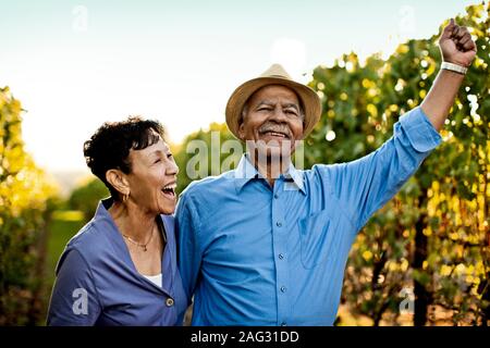 Sehr glücklich senior Paar zu Fuß durch die Weinberge. Stockfoto