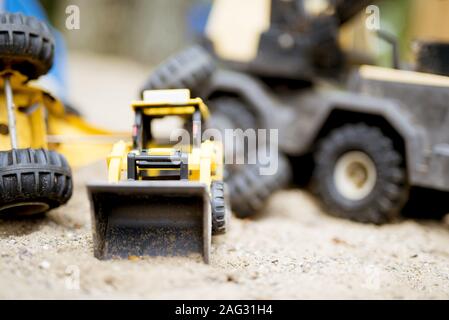 Nahaufnahme eines gelben Bulldozers auf einer sandigen Oberfläche Mit unscharfem Hintergrund Stockfoto