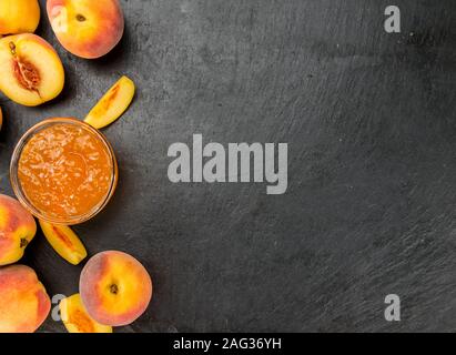 Pfirsich Marmelade auf einem Vintage schiefer Tafel als detaillierte Nahaufnahme; selektive Fokus Stockfoto