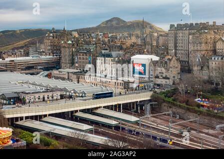 Einem erhöhten Blick auf einen Teil von Edinburgh, mit Blick über den Bahnhof Waverley, der Waverley Bridge und Teil der Altstadt, mit Arthur's Seat im Hintergrund. Stockfoto