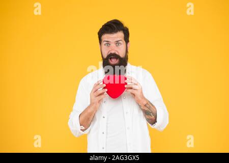 Verschreiben Medikamente senken den Blutdruck Cholesterin. Fühlen pulse check Herzfrequenz Rhythmus. Herzkrankheit. Gesunde Gewohnheiten und Lebensweise. Überwachung und Messung. Man bärtige Hipster halten roten Herzen. Stockfoto