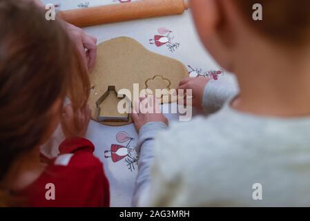 Kinder machen Ingwerbrot-Kekse für Weihnachten Stockfoto