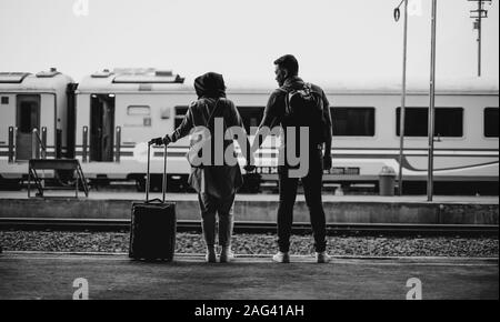 Graues Bild eines Paares, das in einem Zug steht Station Stockfoto