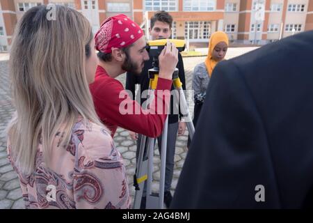 Eine Gruppe von Studenten der Architektur, Praxis Unterricht als Gutachter Engineering. Surveyor Teleskop auf der Baustelle für die Kontur Pläne Stockfoto