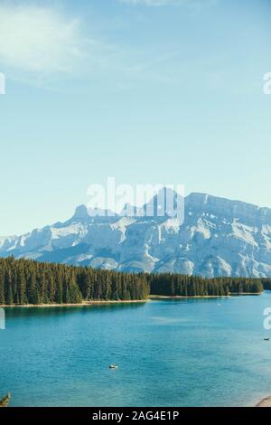 Vertikale Aufnahme eines schönen Flusses neben einem Wald Mit Felsen unter dem Himmel im Hintergrund Stockfoto