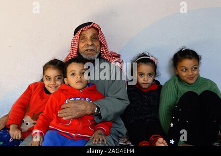 (191218) - GAZA, Dez. 18, 2019 (Xinhua) - suleiman Abu-Namous sitzt mit seiner Familie im Flüchtlingslager Jabalia im nördlichen Gazastreifen, Dez. 17, 2019. Suleiman Abu-Namous aus Gaza vor kurzem stieß einen Seufzer der Erleichterung nach Anhörung, dass das Mandat der Vereinten Nationen für Palästinaflüchtlinge im Nahen Osten (UNRWA) für weitere drei Jahre verlängert werden. Die UNRWA hat ein rettungsseil und ein Anbieter von grundlegenden Dienstleistungen für rund fünf Millionen palästinensischen Flüchtlinge in der Region, einschließlich der 110 Jahre alte Mann und seine Familie. Gehen MIT "Funktion: Palästinensische re Stockfoto