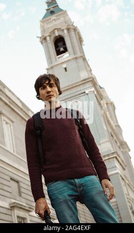 MADRID, Spanien - 18.Oktober 2019: Eine vertikale Shot eines männlichen Touristen in Madrid trägt einen dunklen roten Pullover und Jeans Stockfoto