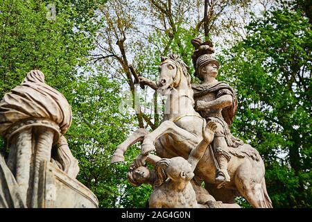 Low-Angle-Aufnahme einer Ritterstatue auf einem Pferd Mit den schönen grünen Bäumen im Hintergrund Stockfoto