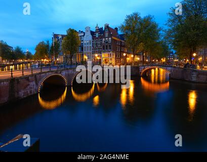 Landschaft von Keizersgracht Kanal in Amsterdam mit der Reflexion von Lichter in der Nähe eines riesigen Gebäudes Stockfoto