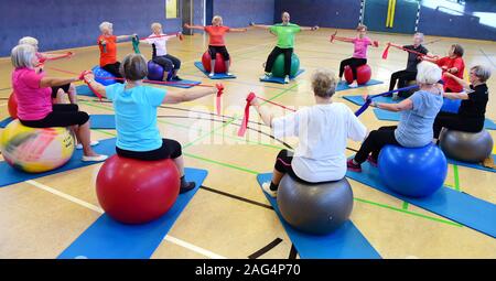 29. November 2020, Sachsen-Anhalt, Halle (Saale): Die 94-jährige Johanna Hofmann (3. von links), im Guinness Buch der Rekorde als ältester aktiver Wettbewerb Turnerin in der Welt aufgeführt, führt Gymnastik im über 80 Gymnastik Gruppe unter der Leitung von Klaus Röpke (Mitte hinten). Für über 20 Jahre hat sie die Frauen, die jetzt fast alle über 80 Jahre, für eine Gymnastik Kurs. Die erfolgreiche, 1,50 Meter hohen, schlanken Frau, Mutter von drei Kindern, Enkeln und Urenkeln, trotz ihres Alter und wenig Schmerzen, beginnt früh im Bett mit Sport exerci Stockfoto