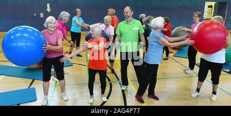 29. November 2020, Sachsen-Anhalt, Halle (Saale): Die 94-jährige Johanna Hofmann (2. von links), im Guinness Buch der Rekorde als ältester aktiver Wettbewerb Turnerin in der Welt aufgeführt, ist Gymnastik in der über 80 Gymnastik Gruppe unter der Leitung von Klaus Röpke (Mitte). Für über 20 Jahre hat sie die Frauen, die jetzt fast alle über 80 Jahre, für eine Gymnastik Kurs. Die erfolgreiche, 1,50 Meter hohen, schlanken Frau, Mutter von drei Kindern, Enkeln und Urenkeln, trotz ihres Alter und wenig Schmerzen, beginnt früh im Bett mit Sport Übungen a Stockfoto