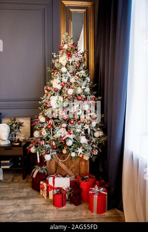 Schöne Ferienwohnung Zimmer dekoriert mit Weihnachtsbaum mit Geschenken unter ihm Stockfoto