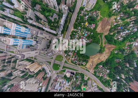 Luftaufnahme der Platz in der Stadt mit Kreisverkehr, Straßen und und viele hohe Gebäude mit grünen Bäumen, mit Drop Effekt Perspektive. Stockfoto