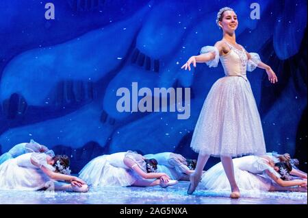 Die Schneekönigin steht vor der Schneeflocken als künstlicher Schnee sanft fällt nach unten um sie herum in einer Generalprobe der Nussknacker Ballett. Stockfoto