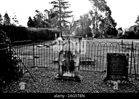 Graustufen Aufnahme von gruseligen Grabsteinen in der Mitte eines friedhof Stockfoto